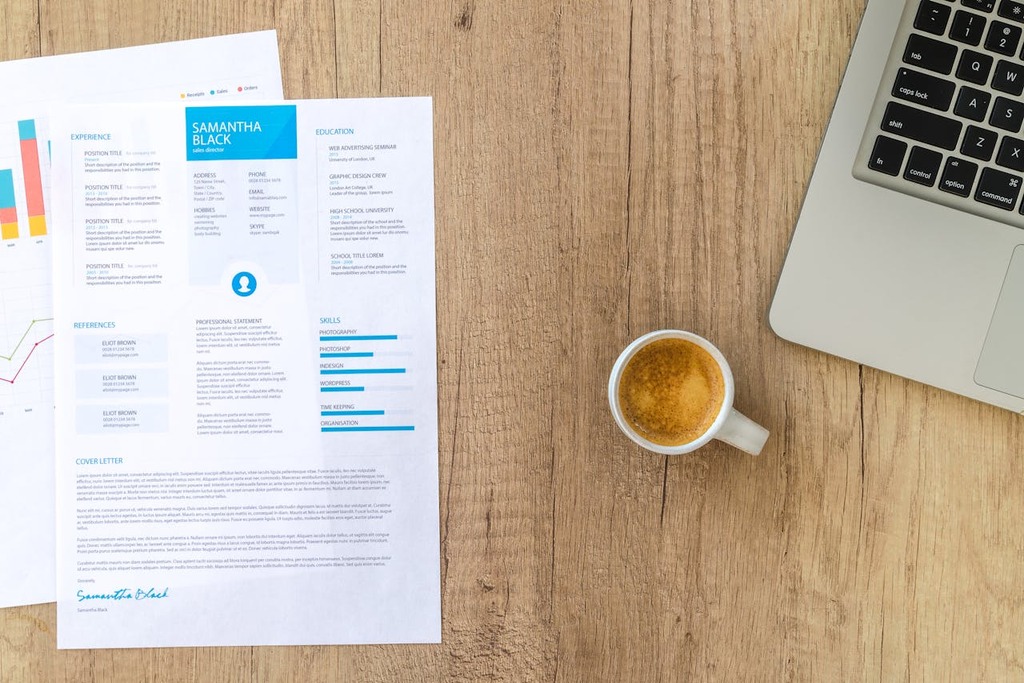 Career transition tips with coffee and laptop setup; A neatly organized resume layout on a desk next to a laptop and coffee, illustrating resume crafting tips for career transitions.