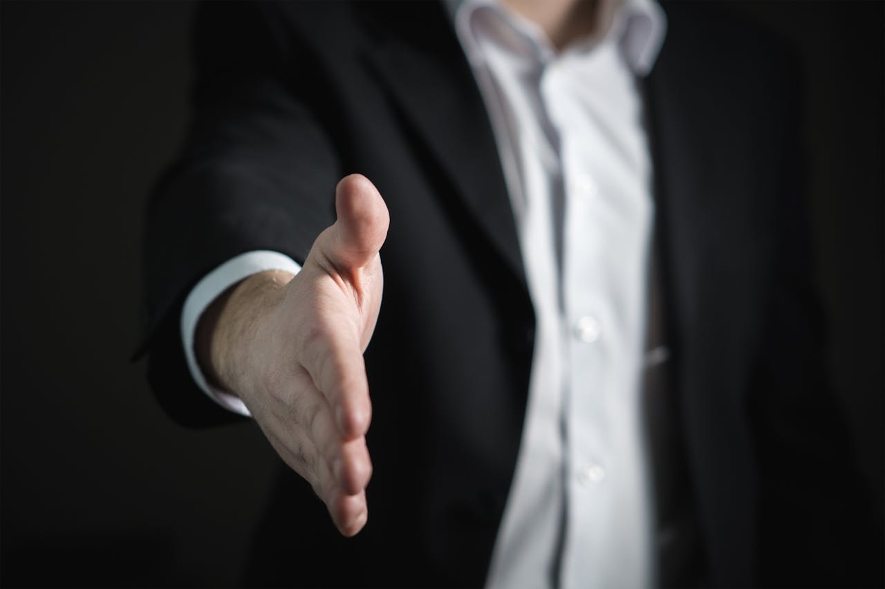 Close-up of a professional handshake at a job fair, symbolizing successful networking and follow-up opportunities.