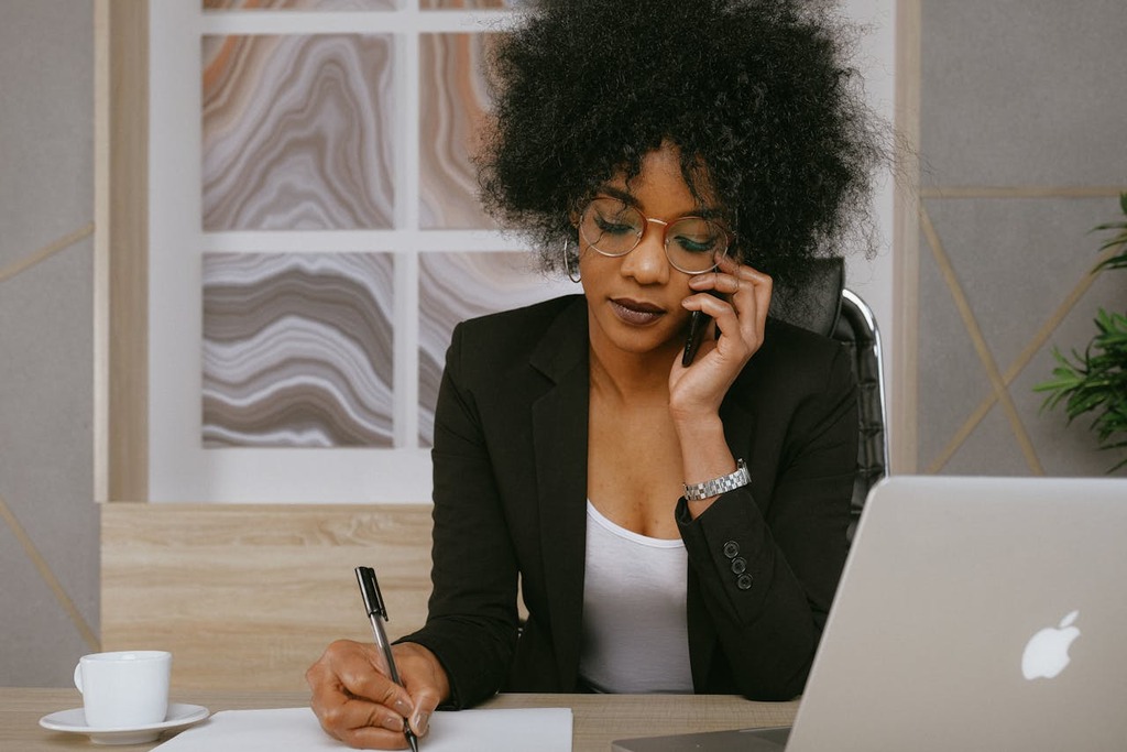 Business consultant in Pittsburgh on a call while reviewing funding options and taking notes for client services.